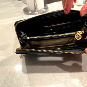 Tory Burch glossy black zippered wallet.